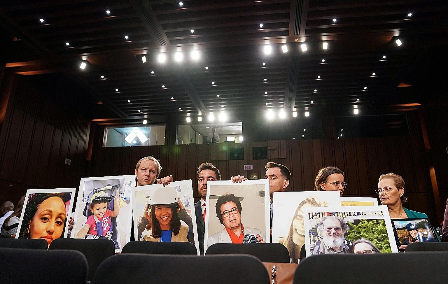 Family members holding photos of victims lost in two Boeing 737 Max crashes that killed 346 people as the planemaker's chief executive testified before a US Senate committee hearing in October 2019.
