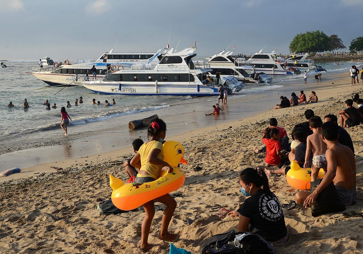 Local residents at a beach in Bali on Sunday. The Indonesian government has so far ignored pleas for a national lockdown to curb the spread of the more infectious Delta variant of the coronavirus, opting only to tighten social restrictions in the wor