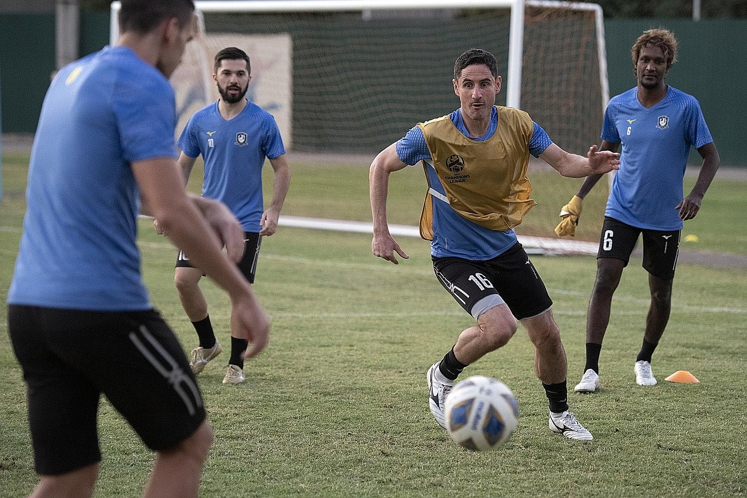 Tampines veteran Daniel Bennett (in bib) chasing the ball down during a training session at Yakkasaray Stadium in Tashkent on Tuesday ahead of today's clash with Gamba Osaka. He endured back-to-back losses against the Japanese giants during his time 