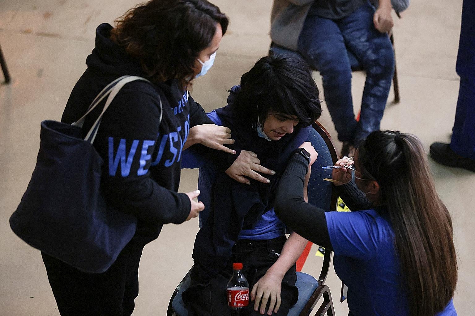 A teenager in Chile's capital Santiago receiving a dose of the Pfizer-BioNTech vaccine on Wednesday. Public Health England found last week that vaccines made by Pfizer and AstraZeneca offer protection of more than 90 per cent against hospitalisation 