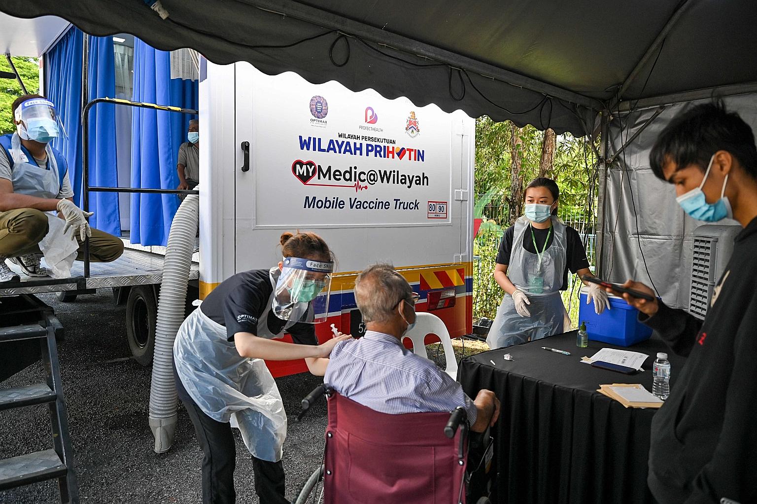 An elderly man getting a dose of the Sinovac vaccine outside a mobile centre in Kuala Lumpur on Monday. PHOTO: AGENCE FRANCE-PRESSE