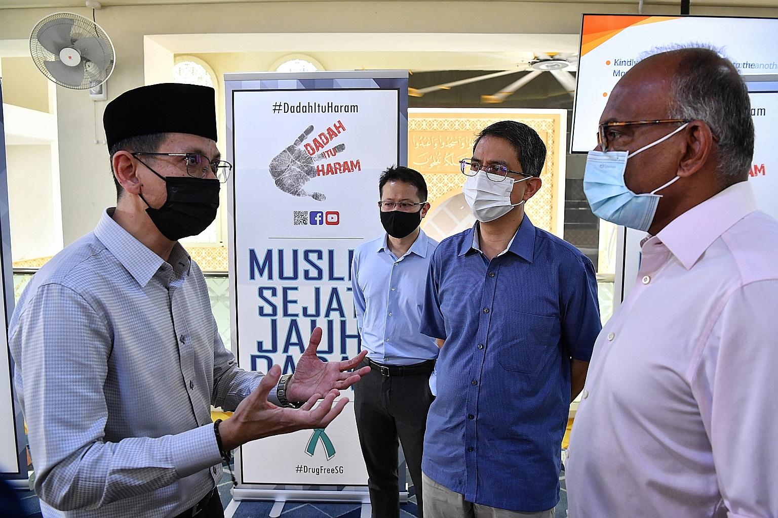 Mr Mohamed Farik Omar (left), deputy director of Fitrah, or the Family and Inmates Through-care Assistance Haven which provides support for inmates and their families, speaking to (from right) Home Affairs and Law Minister K. Shanmugam, Minister of S