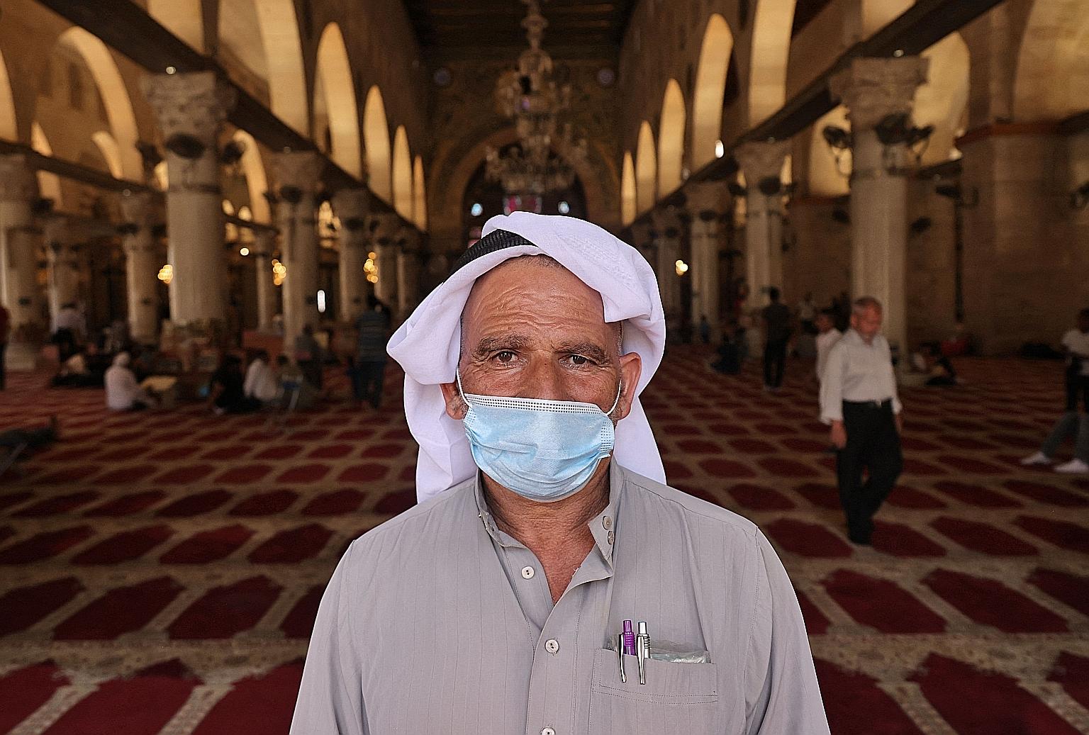 A man wearing a mask in a Jerusalem mosque yesterday, as a mask-wearing rule for enclosed public places kicked in.