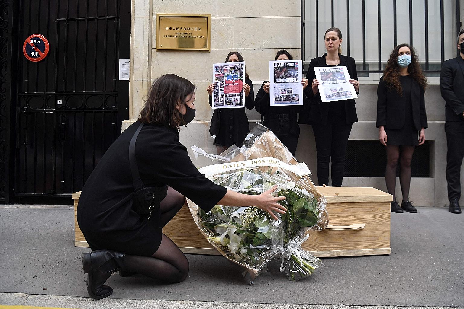 People demonstrating outside the Chinese Embassy in Paris yesterday in support of Hong Kong's Apple Daily newspaper, which was forced to close after its founder Jimmy Lai's assets were frozen. PHOTO: AGENCE FRANCE-PRESSE