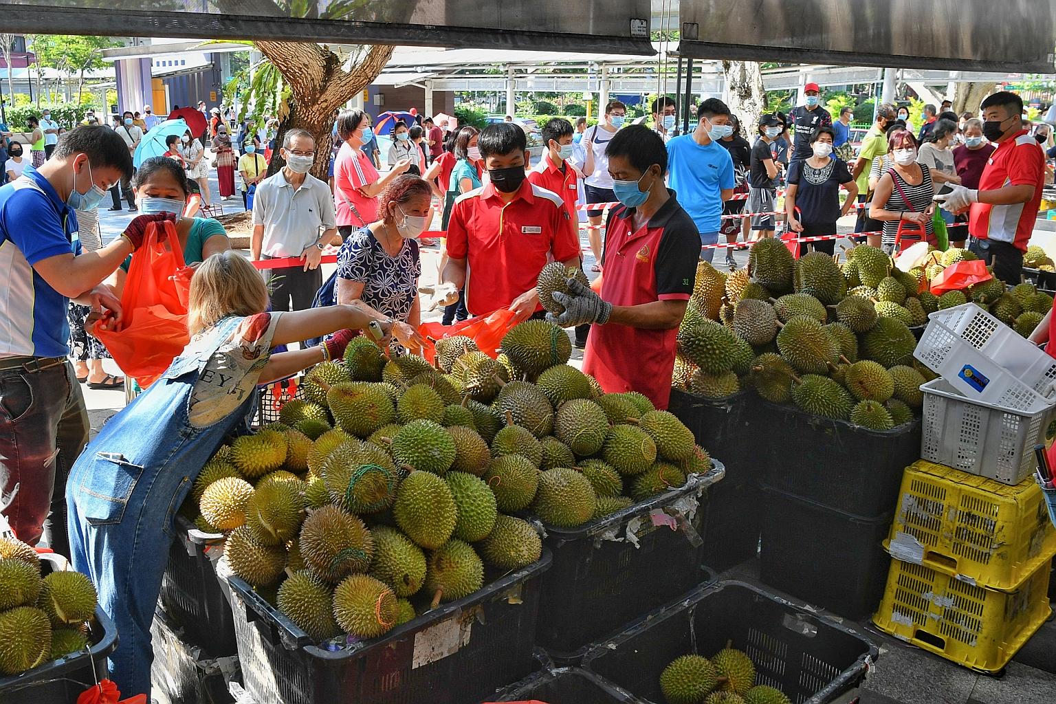 People queueing for durians outside Sheng Siong's Bedok Central store yesterday. Some had travelled from as far away as Sengkang and Hougang to get a good deal on the spiked fruits. Many of them had seen the supermarket's Facebook post on Wednesday t