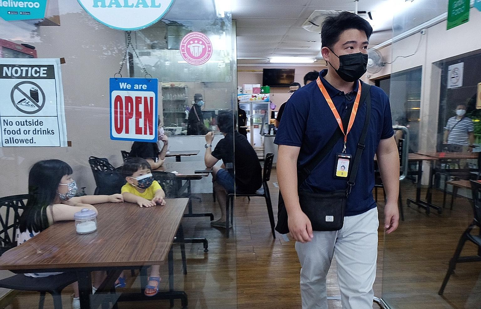 Enforcement officer Aldric Ang making sure safe management measures were followed at an F&B outlet in Jalan Leban yesterday.