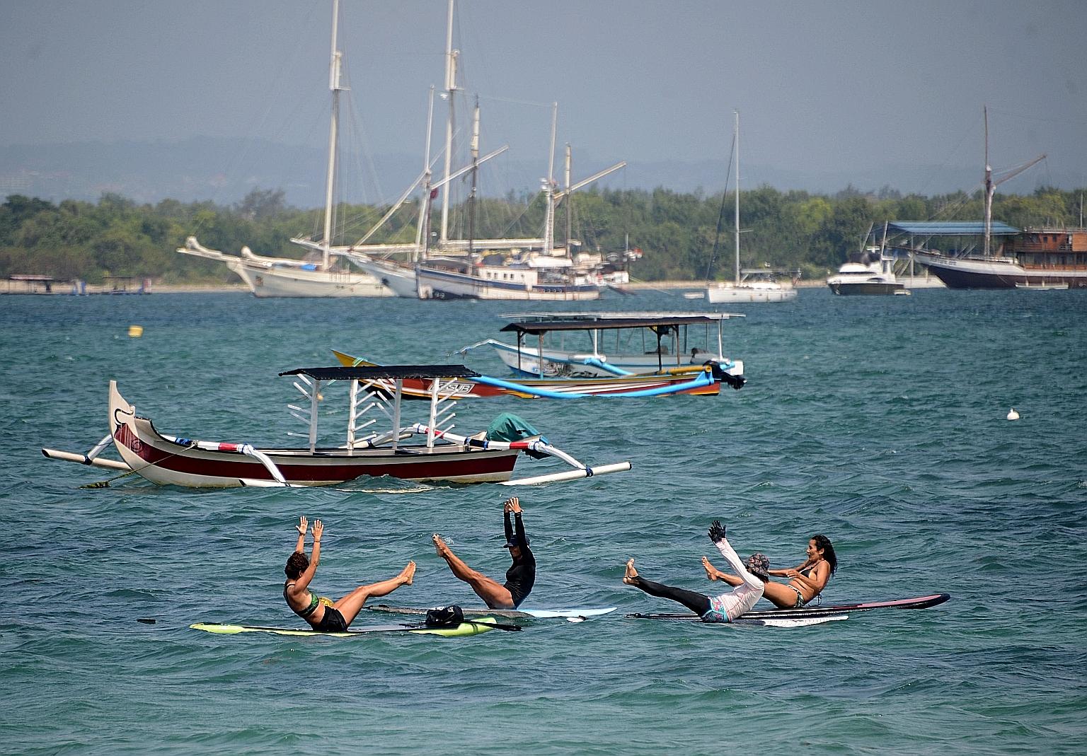 People doing yoga on paddle boards at Sanur beach in Bali last month. Indonesia plans to allow entry of tourists into Bali from several countries considered as low-risk for Covid-19 in the third quarter of this year, under a travel corridor which the