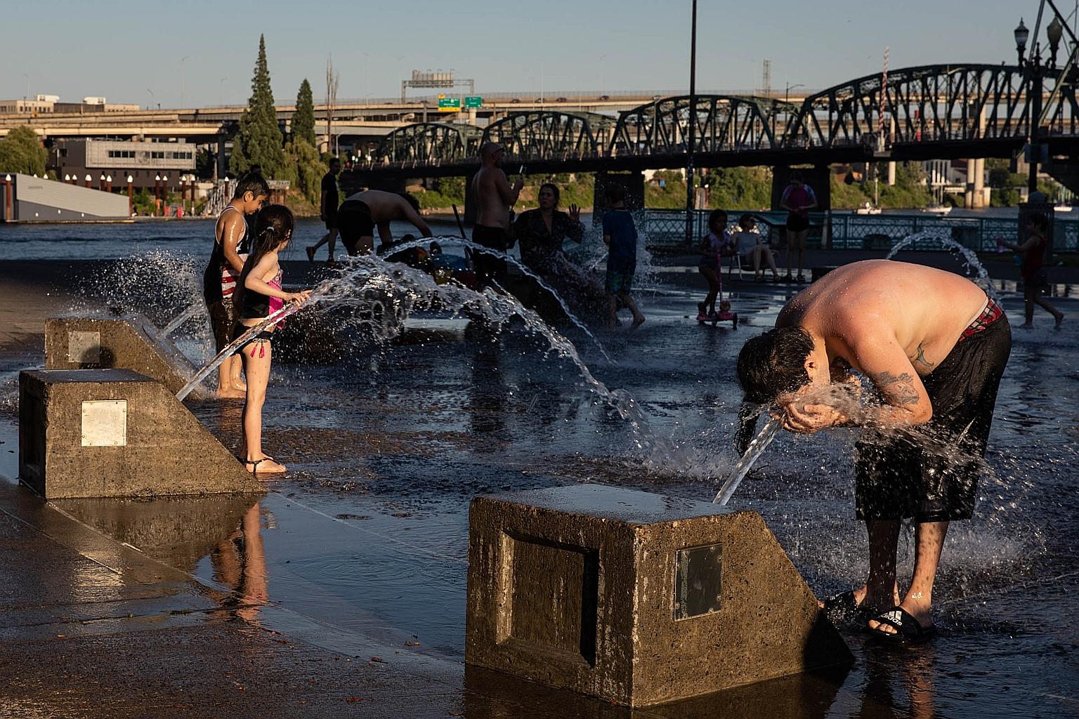 A boy cooling off at a water fountain in Portland, Oregon, on Saturday. Residents were warned of "life-threatening" heat.