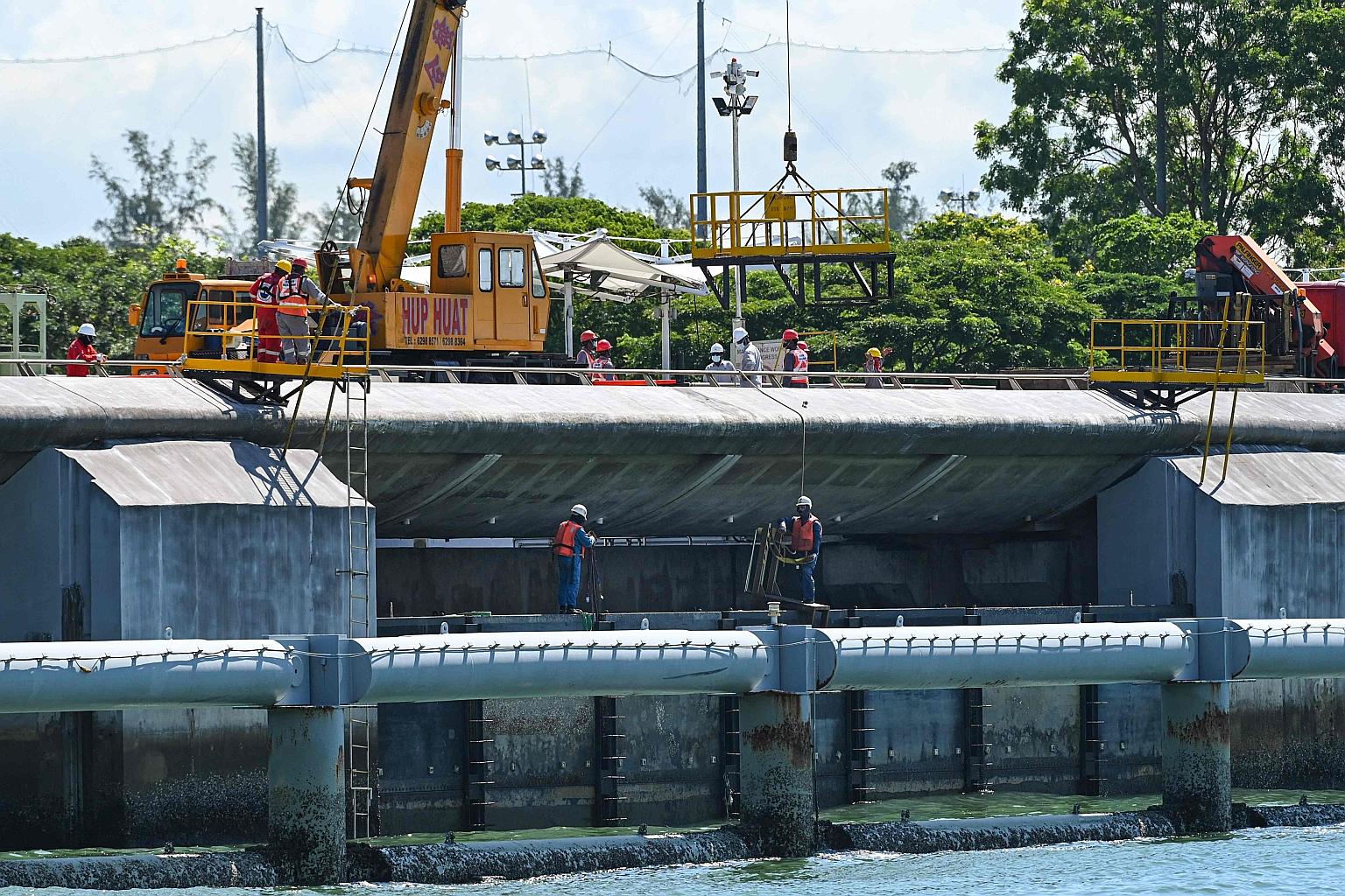 Workers carrying out maintenance work at the Marina Barrage dam earlier this month. The barrage not only serves as a dam for flood control but is also a source of fresh water and a recreational space for many.