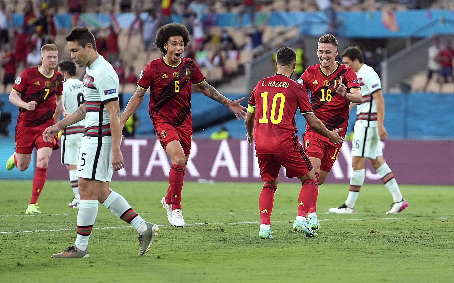 Belgium midfielder Thorgan Hazard (No. 16) celebrating his goal against Portugal with brother Eden and Axel Witsel. The goal proved to be the winner and Belgium will next face Italy in the quarter-finals on Friday.