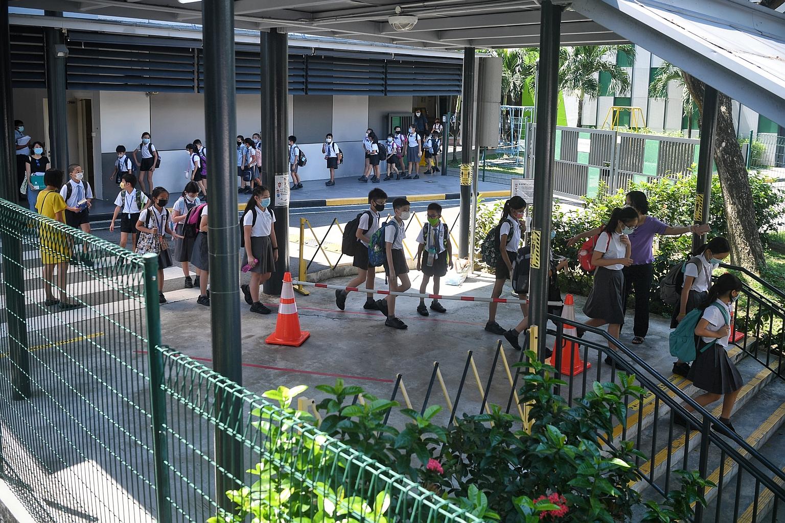 Alexandra Primary School pupils leaving school yesterday, which marked the start of a new term. It was also the first time students have been allowed back in school since Singapore eased its strict rules on in-person gatherings and stepped up its vac