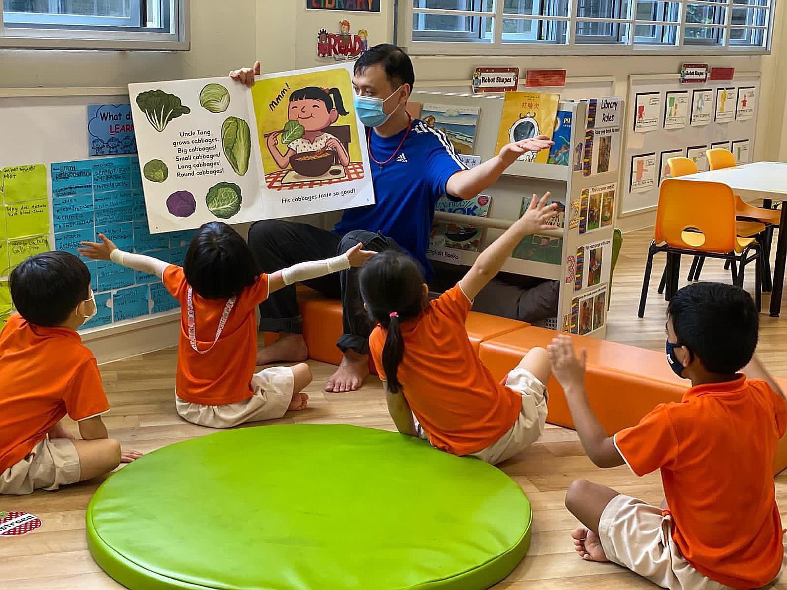 Mr Kevin Teo, 36, an English teacher at My First Skool at Block 82 Strathmore Avenue, reading a book with the children. "Being the only male figure here, it helps the children to have interactions with male adults, because when they go outside it's n