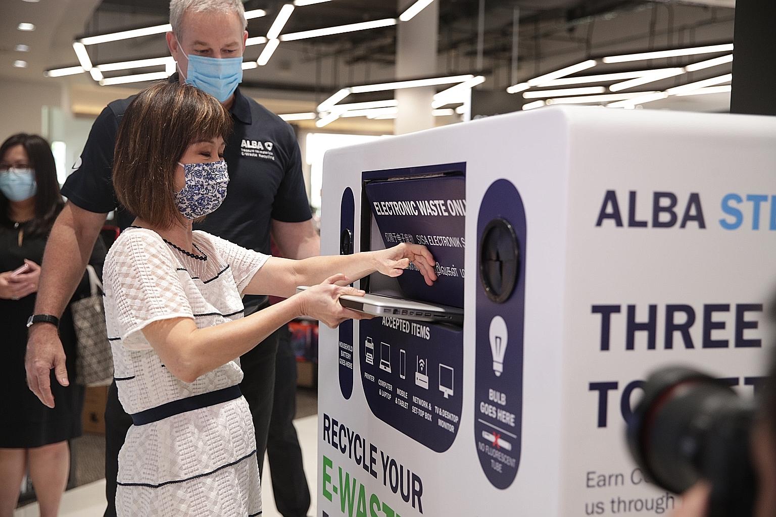 Senior Minister of State for Sustainability and the Environment Amy Khor trying out the e-waste collection bin at Harvey Norman Millenia Walk yesterday. With her is Alba E-Waste general manager Fons Krist. ST PHOTO: TIMOTHY DAVID
