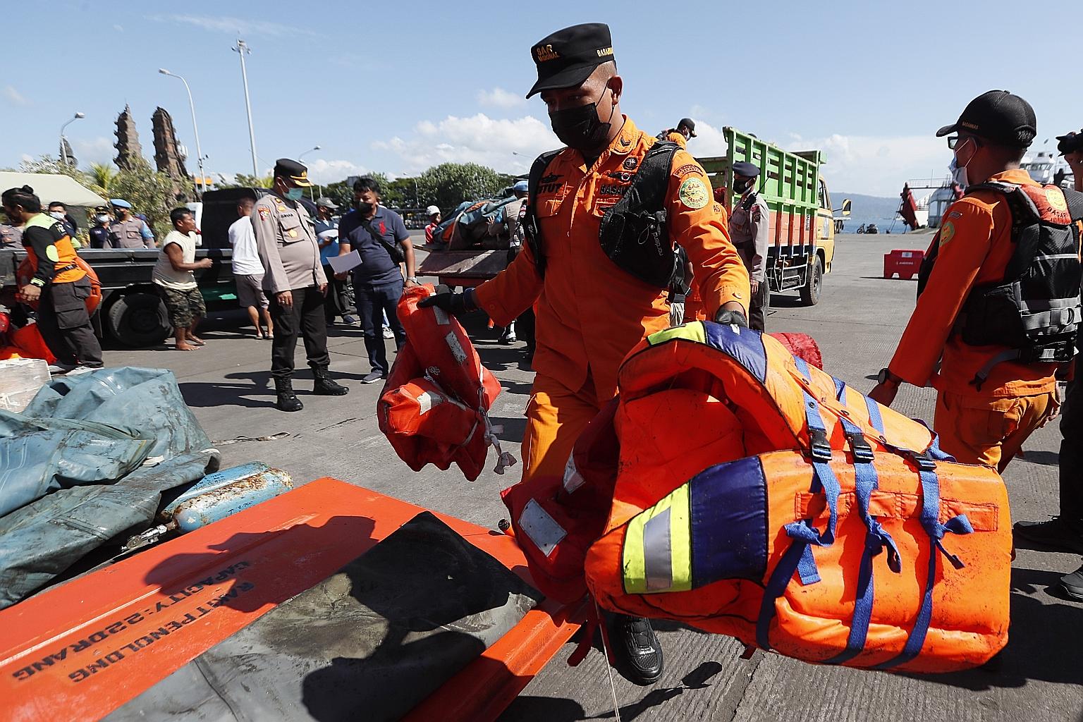 A rescue worker with life vests believed to be from the KMP Yunicee ferry at Bali's Gilimanuk port yesterday. The ferry was carrying 57 passengers and crew when it went down in rough seas. PHOTO: EPA-EFE