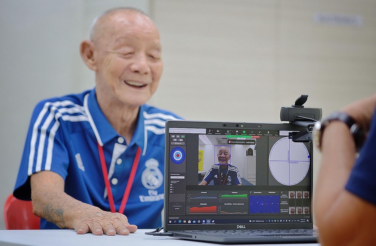 Lions Befrienders counsellor Stephen Ong (foreground) giving a live demonstration of the software program yesterday, with an 83-year-old client who wanted to be known only as Mr Lai. The program measures facial expressions, mapping positive and negat