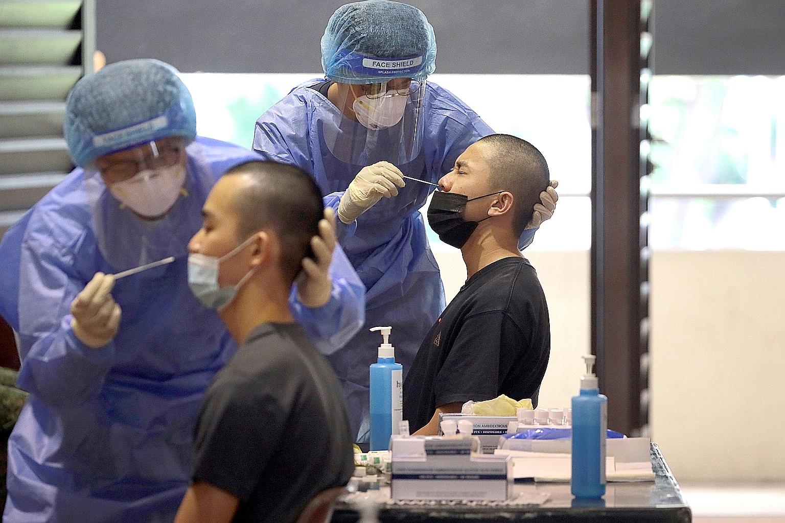 National service enlistees undergoing Covid-19 swab tests at Selarang Camp on Tuesday. Pre-enlistment vaccination was rolled out last month for recruits before they entered the Basic Military Training Centre. Last year, basic military training was su