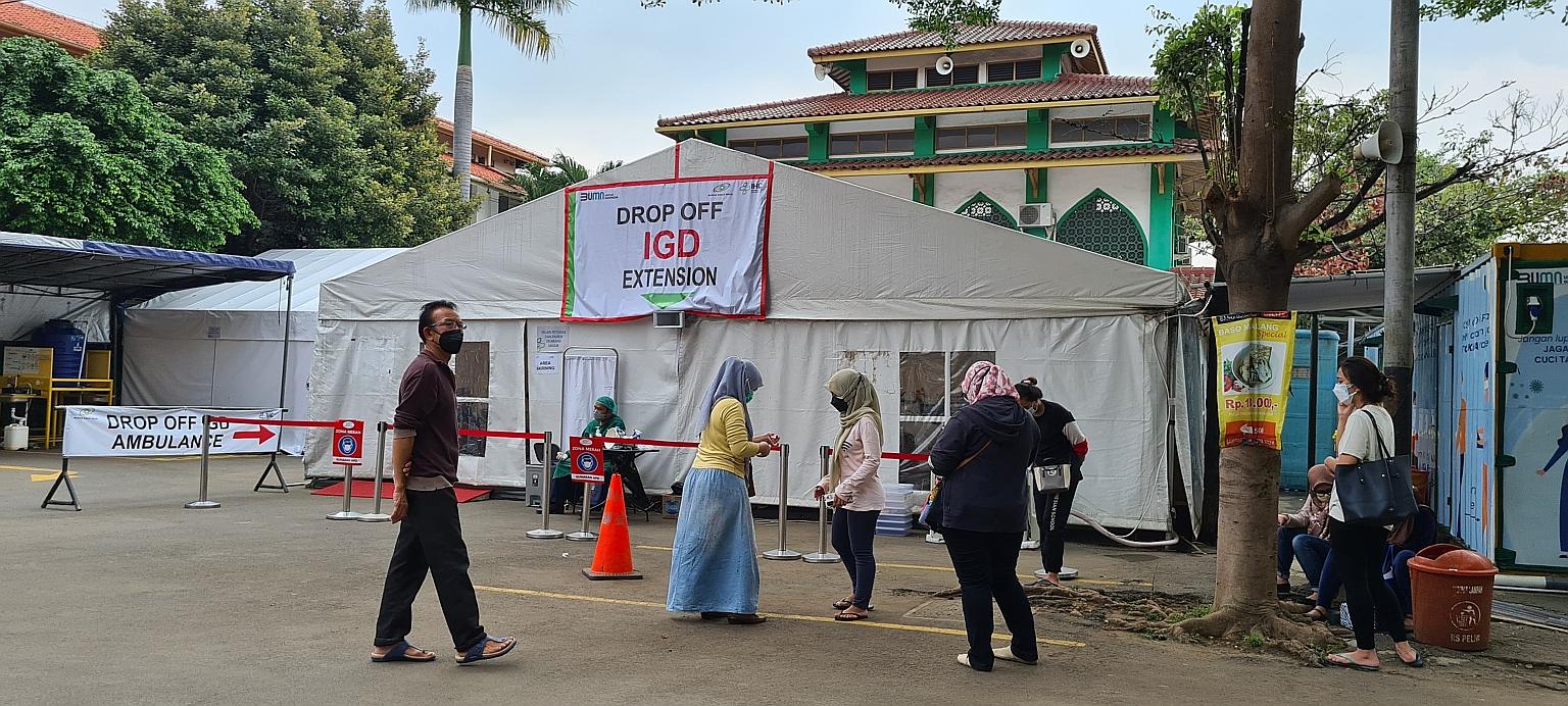 Jakarta residents waiting for their family members to be examined at a tent which Pelni Hospital has turned into its emergency unit due to a surge of Covid-19 patients. Many families of Covid-19 patients are struggling to find hospital beds as bed oc