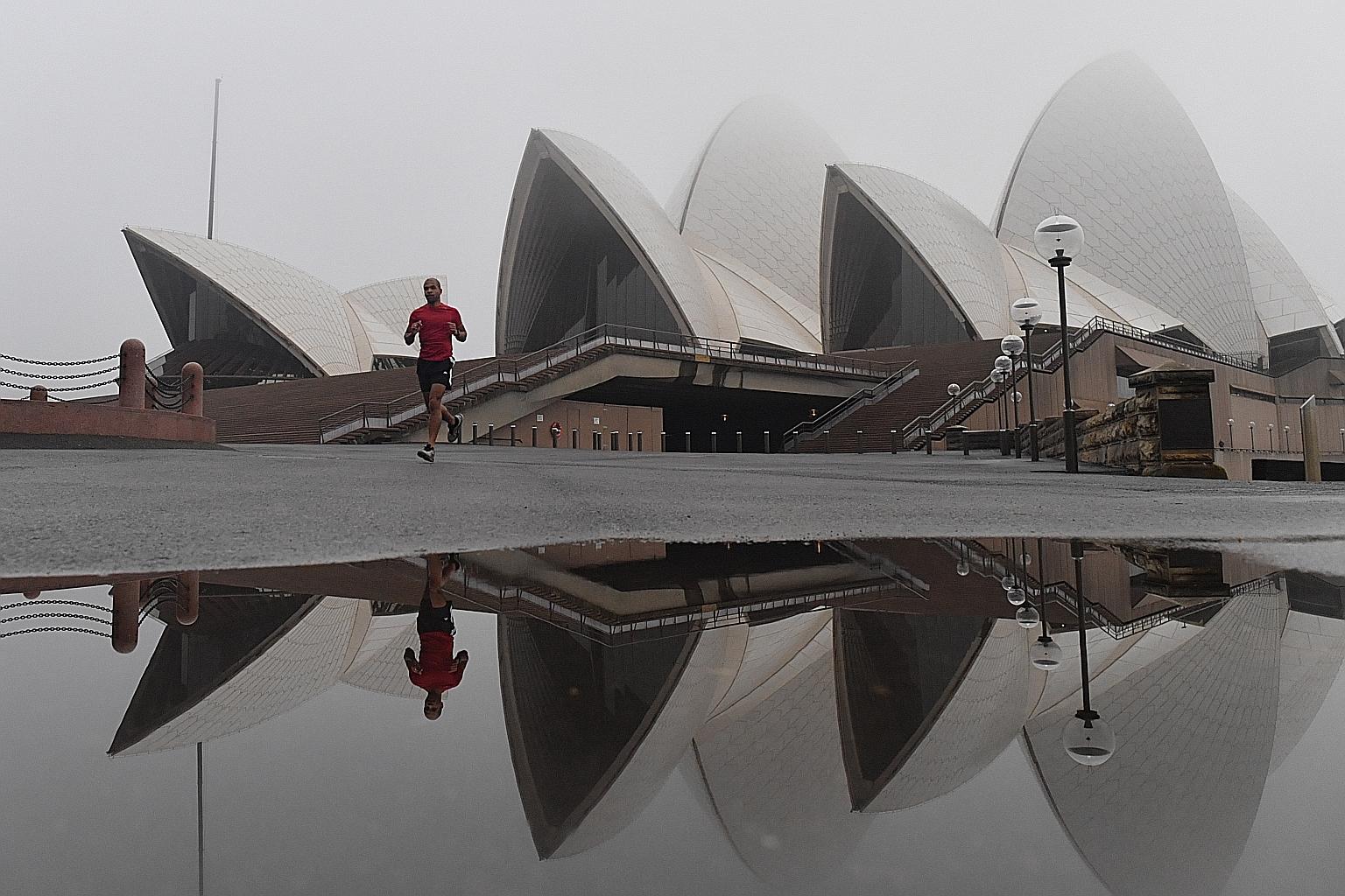 The Sydney Opera House shrouded in fog in Sydney yesterday. With more than five million residents of greater Sydney under a lockdown until July 9, New South Wales state reported 22 new locally transmitted Covid-19 cases yesterday, all linked to prior