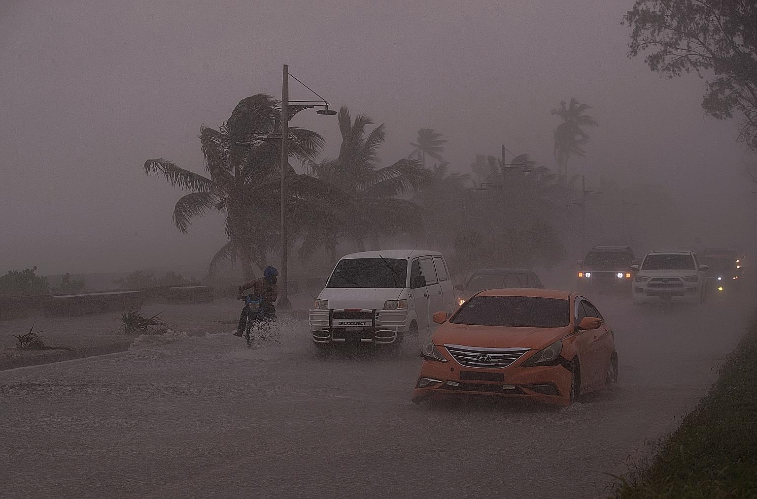 Vehicles buffeted by intense rain and winds during the passage of tropical storm Elsa in Santo Domingo, the capital of the Dominican Republic, on Saturday.
