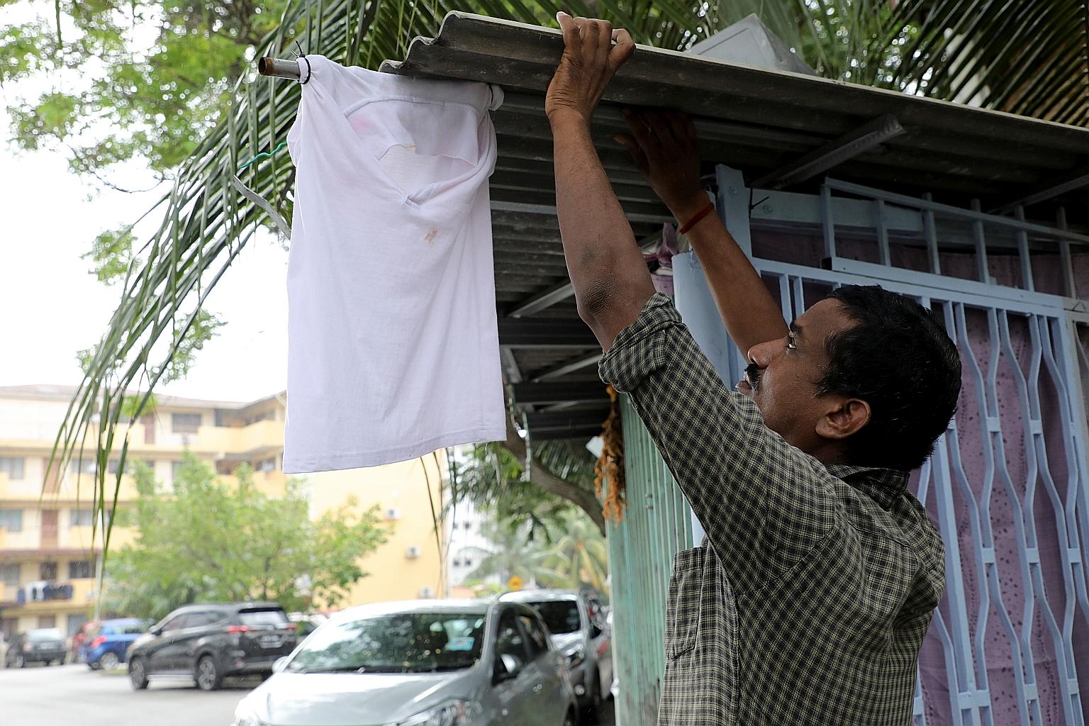 Mr Sasikumar, 45, a car cleaner who had lost his job during the lockdown, attempting to seek help from the public by hanging a white flag outside his home in Kuala Lumpur on Monday. PHOTO: REUTERS