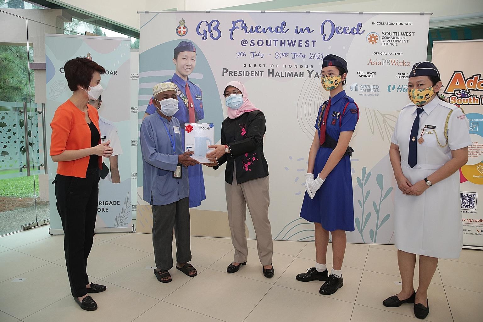 President Halimah Yacob, with South West District Mayor Low Yen Ling (far left), presenting Mr Mohd Saleh Abu with his electric kettle.