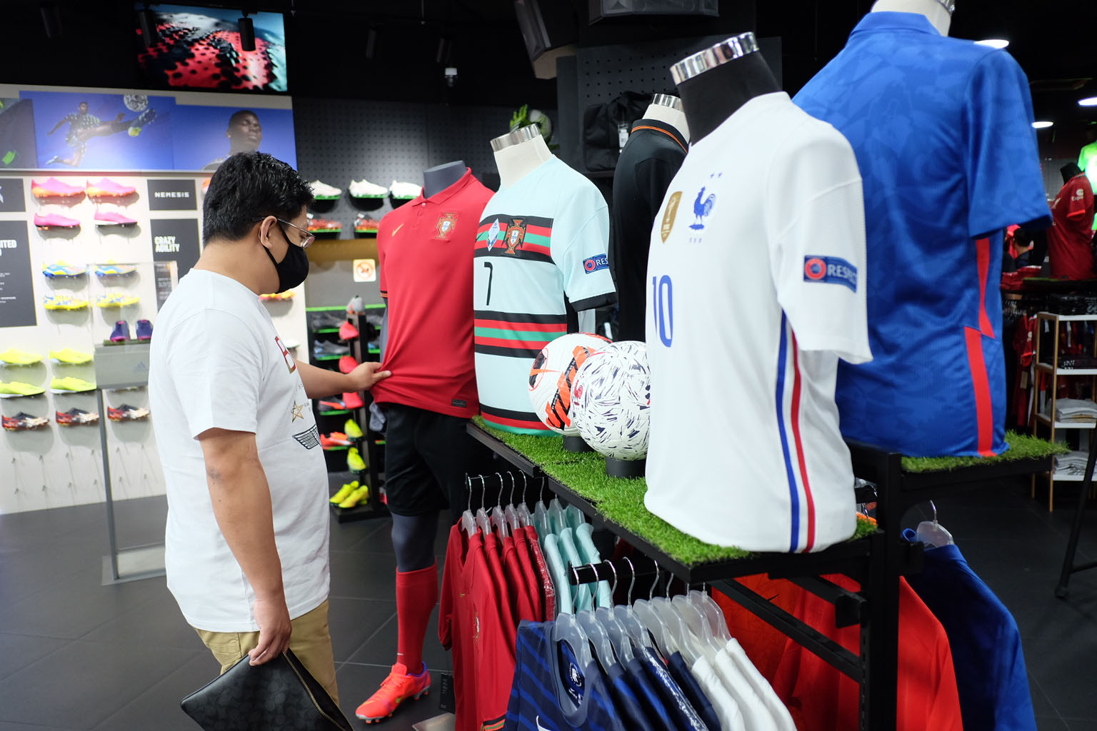 A customer checking out the jerseys of the Euro 2020 teams at football merchandise retailer Weston Corp's VivoCity outlet. ST PHOTO: MOHD KHALID BABA