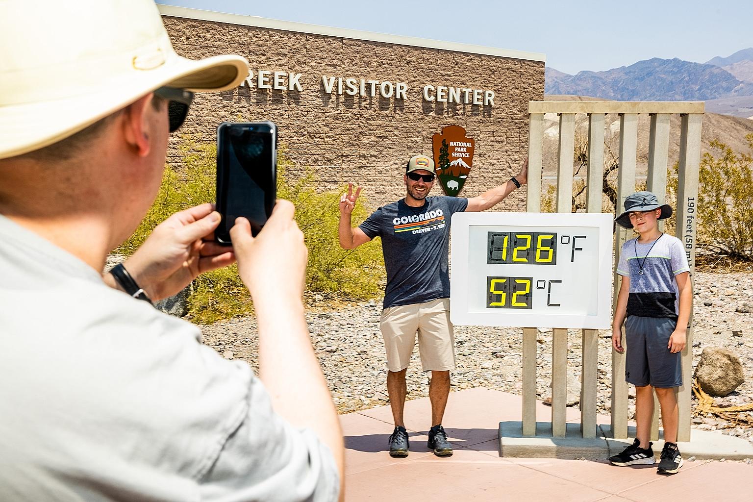 Visitors taking photos in front of a thermometer showing the soaring mercury at the visitors' centre at Death Valley National Park in California on Saturday.