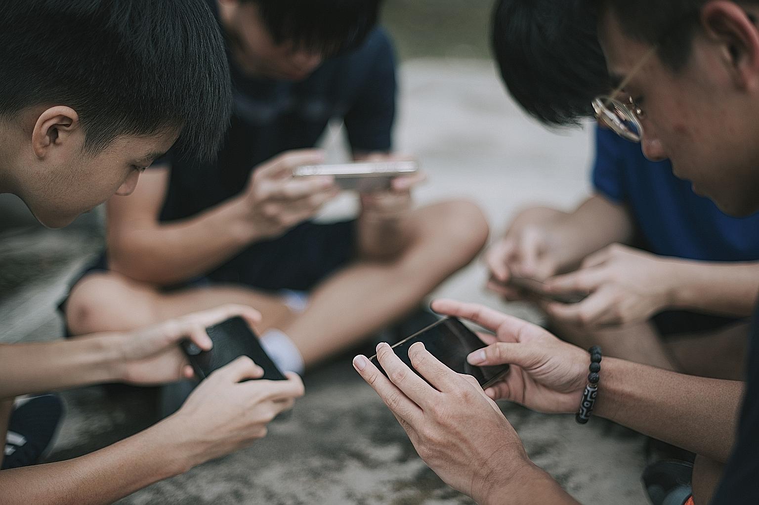 A group of teenage boys playing mobile games on their phones. In 2019, a cyber curfew was imposed in China banning those under 18 from playing games between 10pm and 8am, as part of regulations aimed at limiting screen time and keeping Internet addic