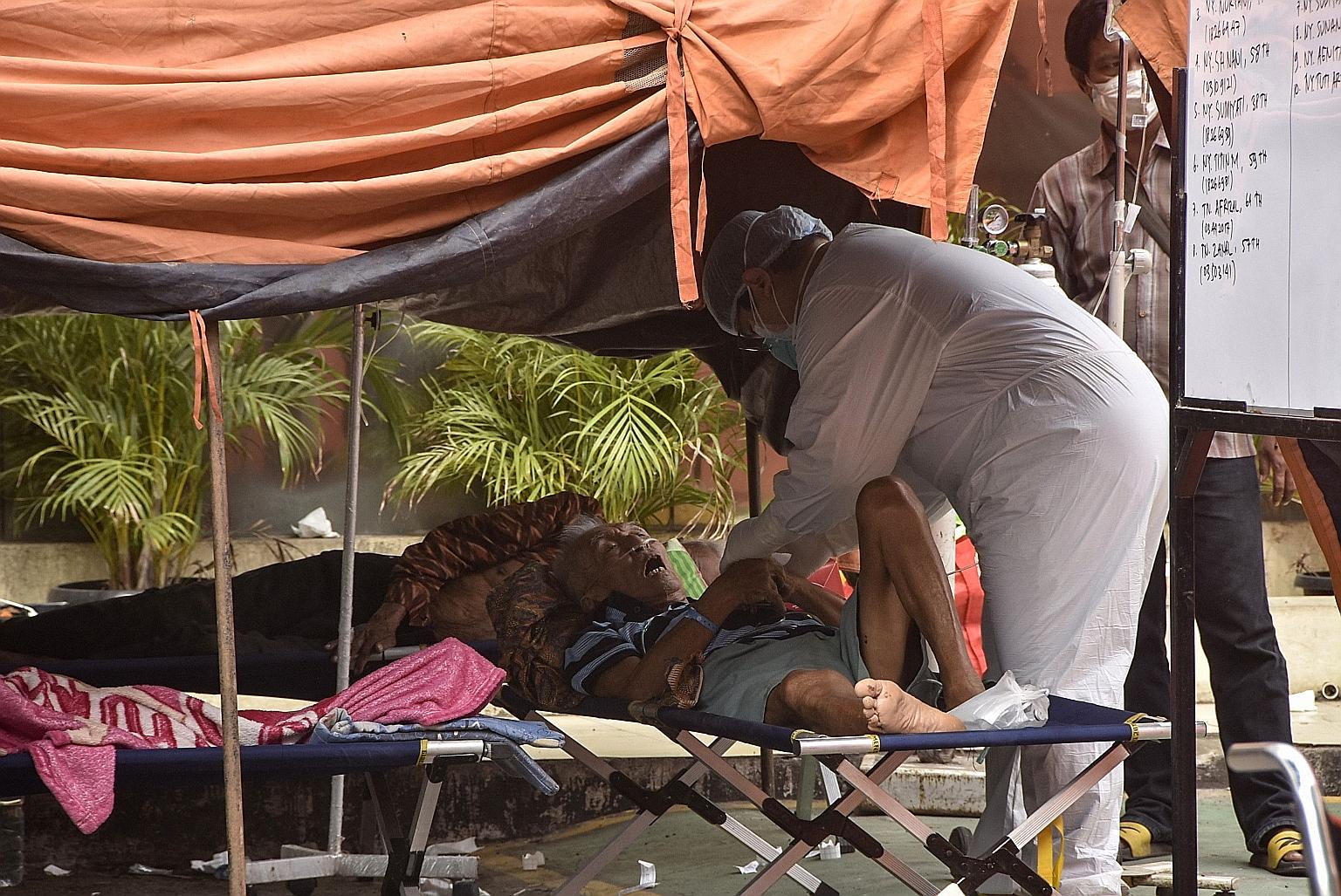 Covid-19 patients being treated in a tent outside a hospital in Bekasi. Indonesia recorded 54,517 infections yesterday.