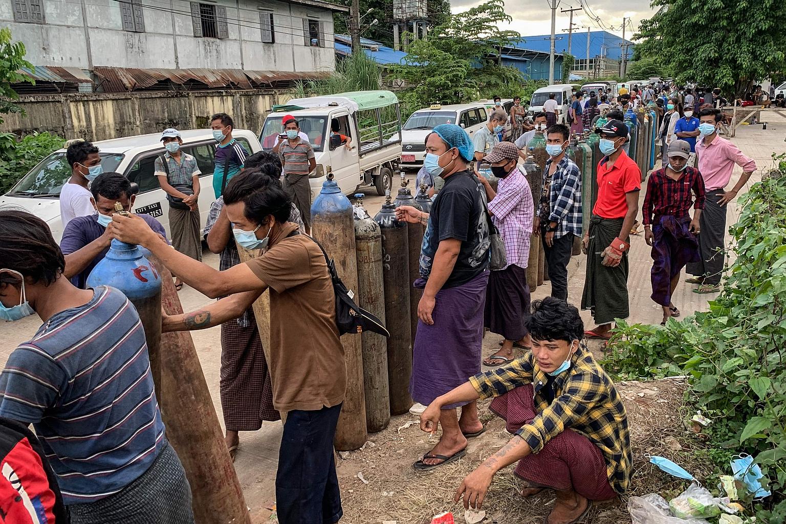 People waiting to fill up empty oxygen canisters outside a factory in Yangon on Wednesday. Doctors say the military is trying to ensure the scarce oxygen supply is funnelled to its own hospitals, which cater to army families. Denying oxygen to privat