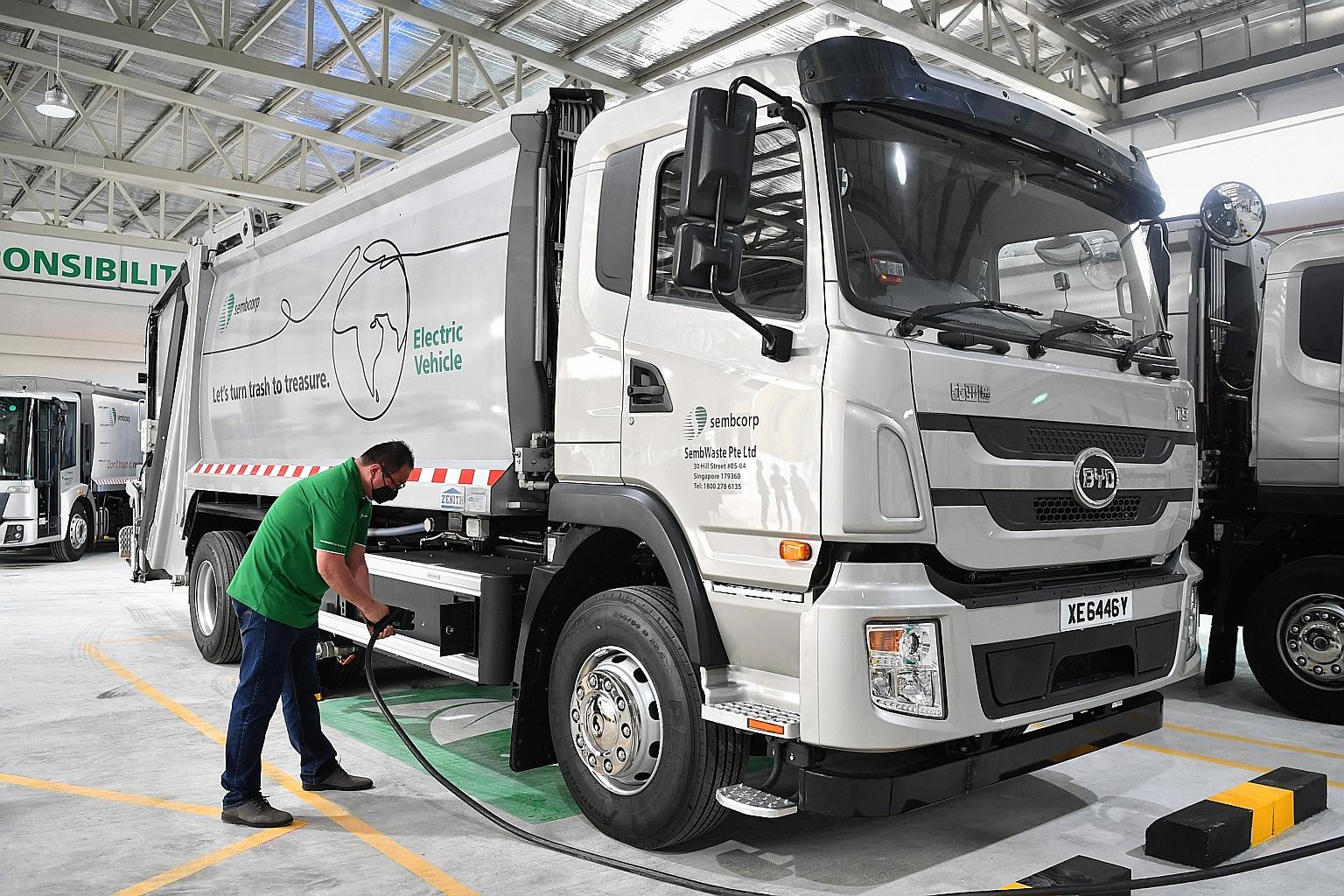 An employee charging a truck at the electric vehicle charging hub in Sembwaste's Tuas depot. It will serve as a central charging station for a fleet of electric trucks deployed this month to collect waste and recyclables in the Clementi-Bukit Merah a