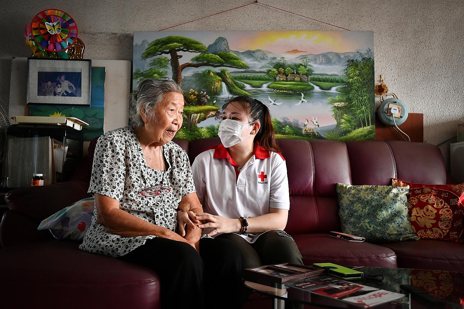 Marine engineer Maggie Chan - a volunteer with the Singapore Red Cross befriending and wellness programme, ElderAid - visits 88-year-old Madam Chen Chin Chee monthly, bringing her food, hand sanitiser and masks. ST PHOTO: LIM YAOHUI