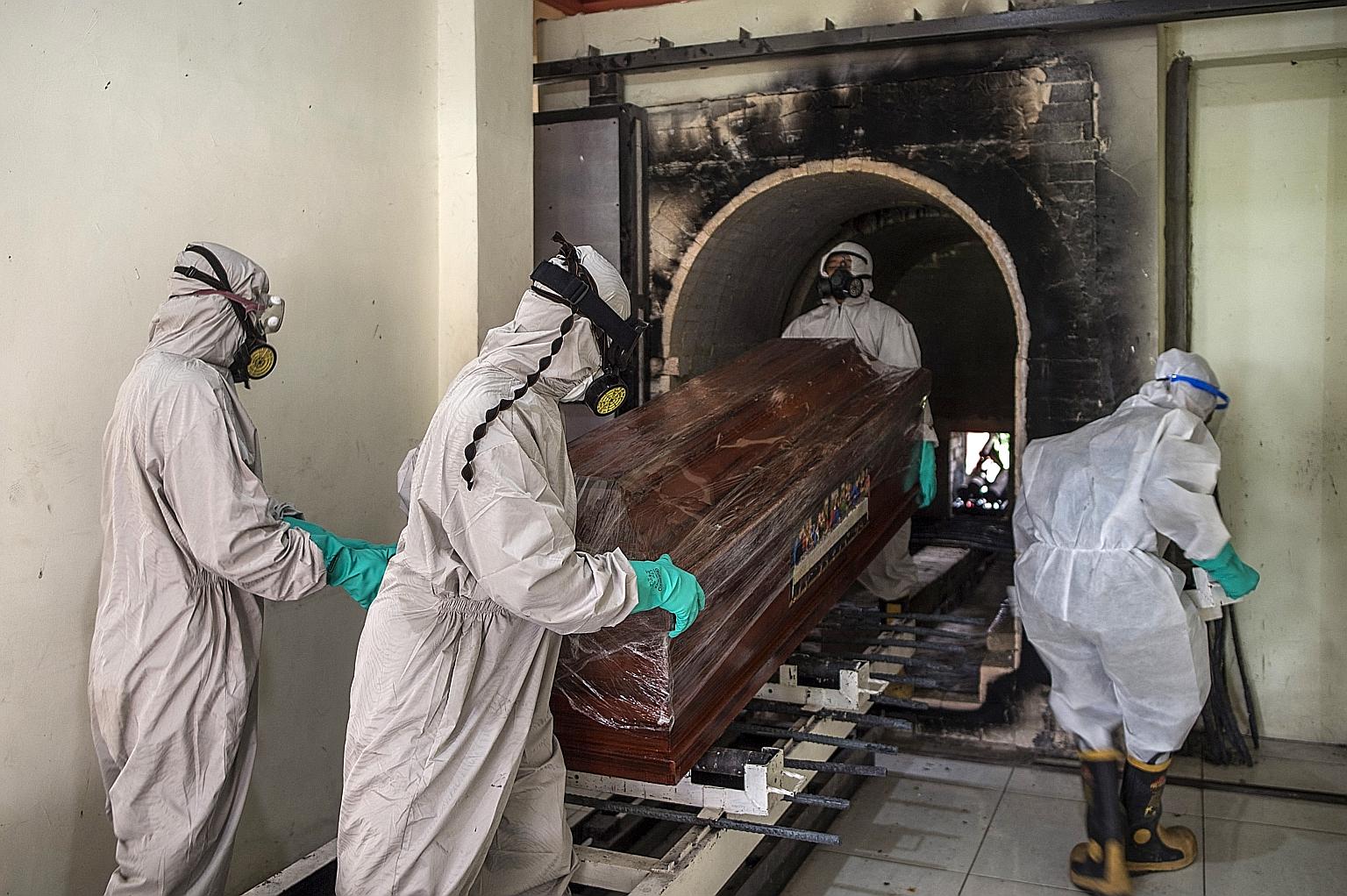 A January photo of funeral workers moving a sealed coffin containing a coronavirus victim ahead of its cremation at Keputih crematorium in Surabaya, East Java. Crematoriums in Indonesia have been hiking their fees, citing higher costs such as paying 