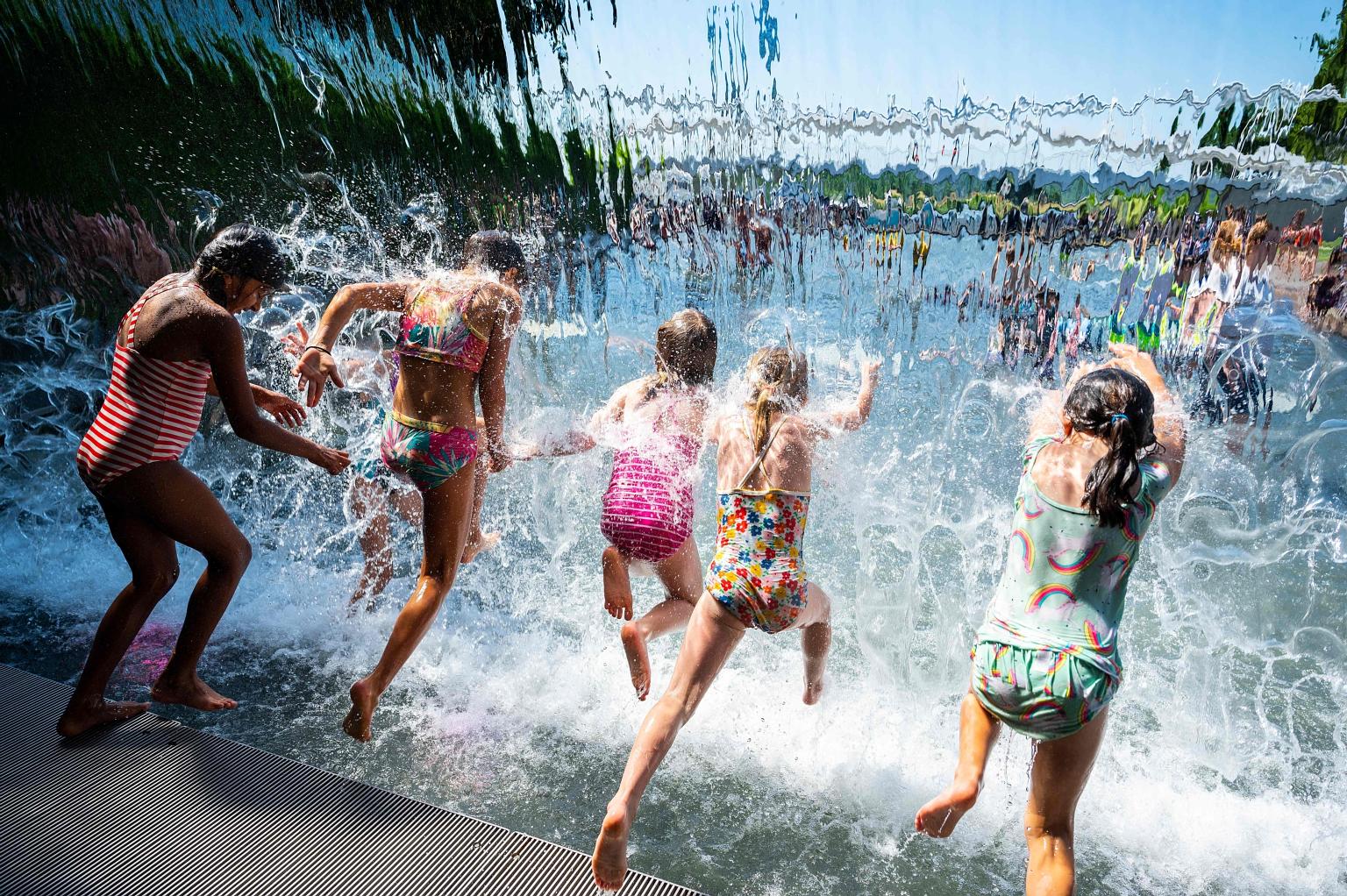 Children jumping into a pool at a park in Washington last month, amid a heatwave across much of the United States. A new study warns that current rates of warming - about 0.2 deg C per decade - are likely to continue for at least another 10 to 20 yea