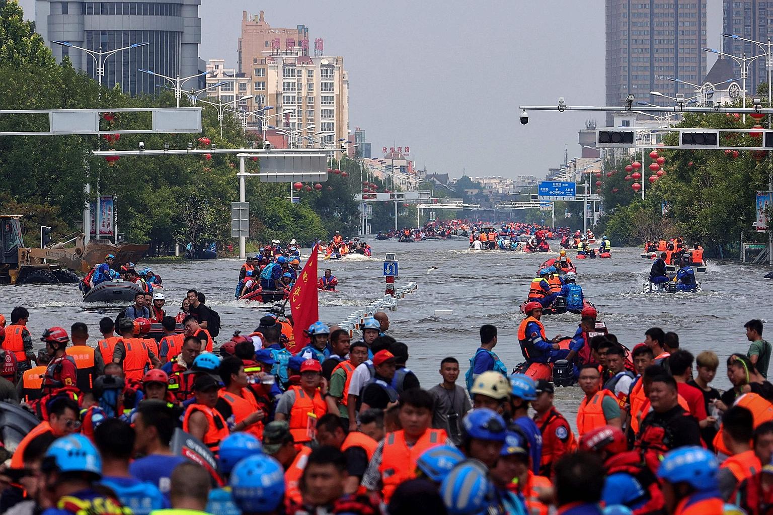 Rescuers evacuating people from a flooded area in Xinxiang, China's central Henan province, on Sunday. Heavy rain that began on July 17 have hit almost 13 million people and damaged nearly 9,000 homes.