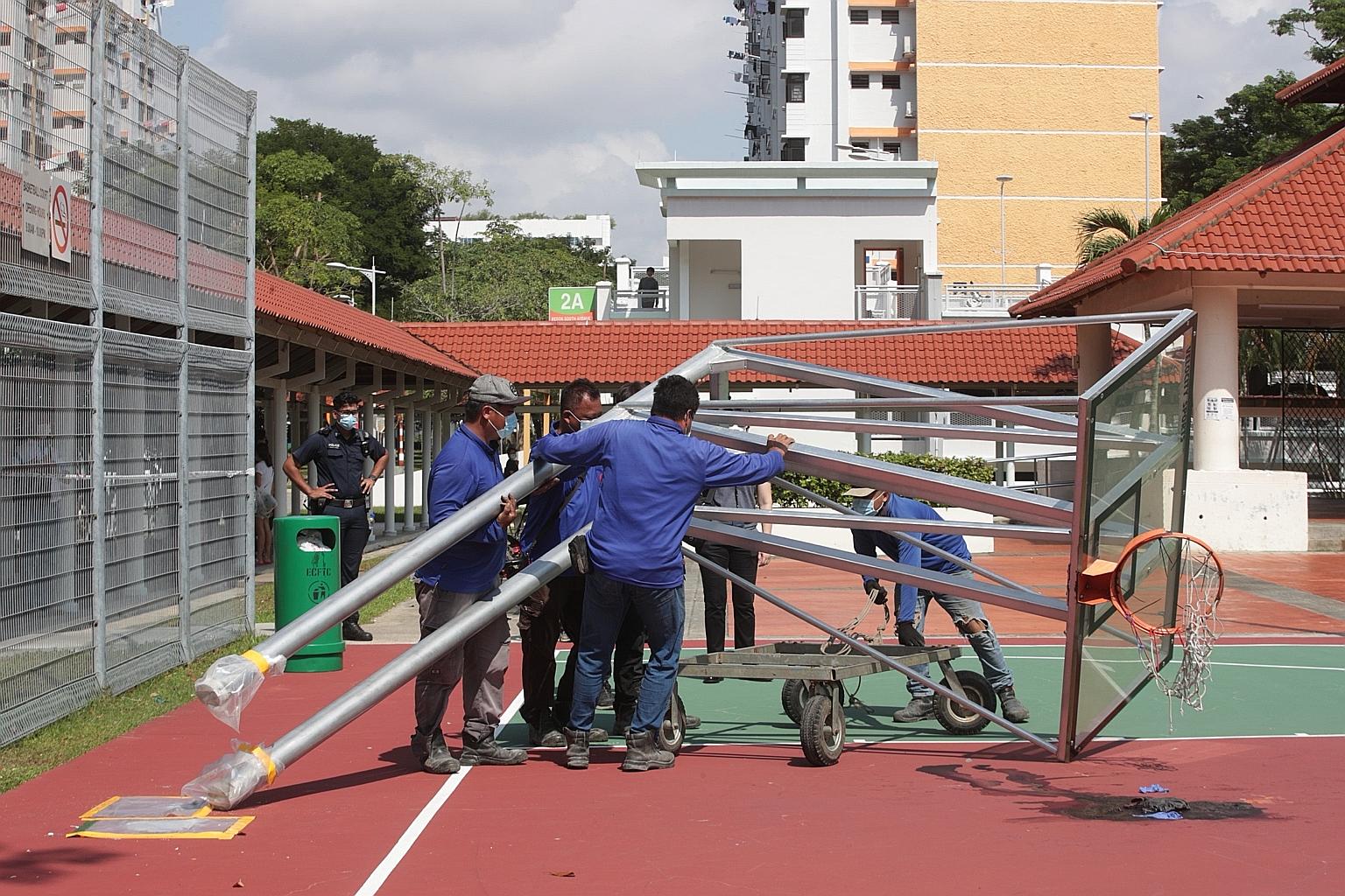 Workers from a contracted company removing the collapsed basketball stand from the basketball court near Block 18 Bedok South Road. The East Coast Town Council said in a Facebook post yesterday that the court had been closed for checks on the integri