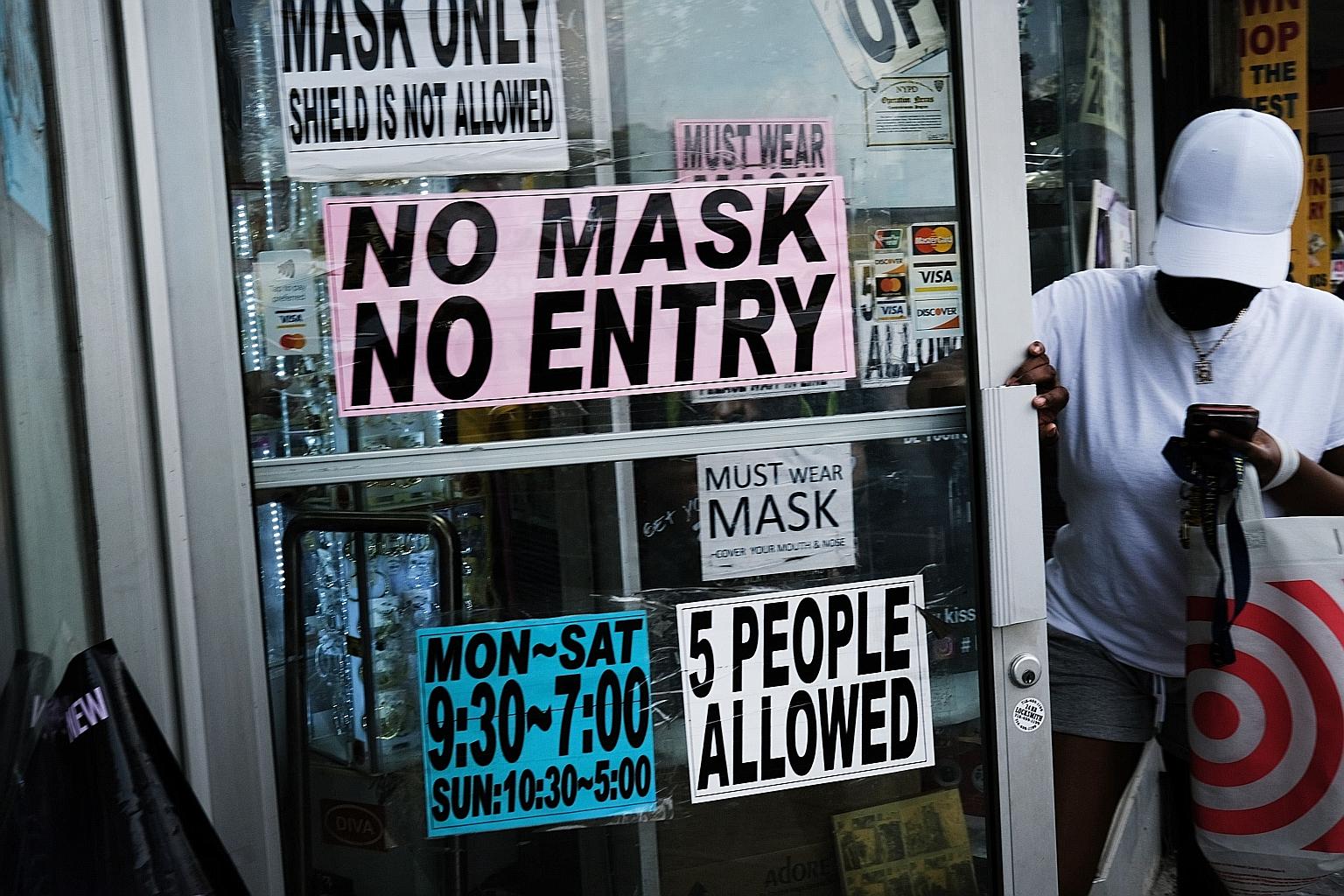 People walking out of a Brooklyn, New York City store, which requests that people wear masks. New York City Mayor Bill de Blasio has announced that the city will require all city workers to be vaccinated or be tested weekly for Covid-19. PHOTO: AGENC