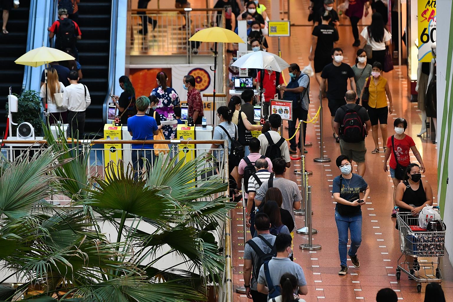 People queueing to check in with SafeEntry at Jurong Point shopping mall on Tuesday. The focus is shifting away from the number of daily Covid-19 cases to the condition of such cases as the nation moves towards living with endemic Covid-19. ST PHOTO: