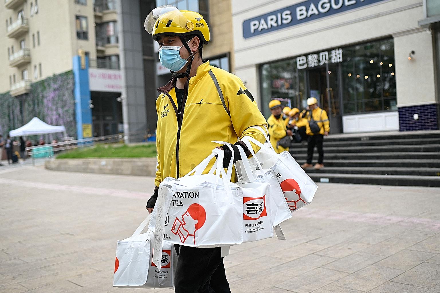 A Meituan worker delivering drinks in Beijing. Meituan and rival Alibaba-owned Ele.me have come under fire after local media exposed the dangerous routes taken by drivers on tight delivery deadlines. Employers must now enforce minimum salary levels a