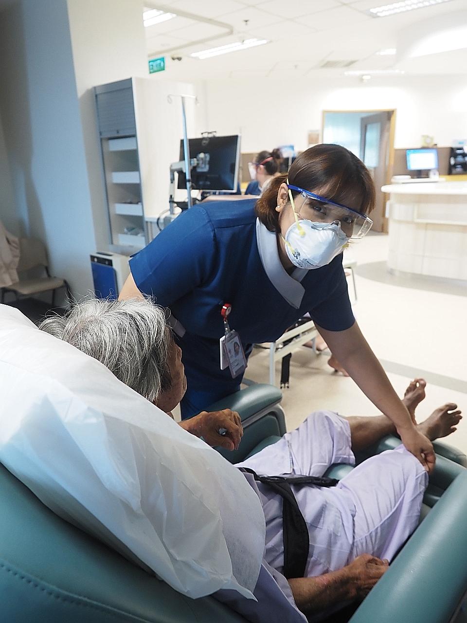 Ms Prema Harrison attending to a patient. She also worked during the Sars epidemic in 2003 and the H1N1 crisis in 2009.