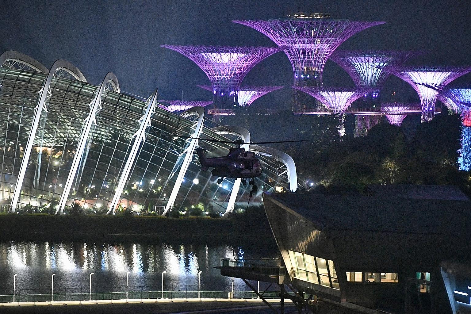 A Republic of Singapore Air Force Super Puma helicopter flying towards the F1 Pit Building last night. It was one of two such helicopters that airlifted troops from the Special Operations Task Force to an outdoor porch area of the F1 Pit Building. Af