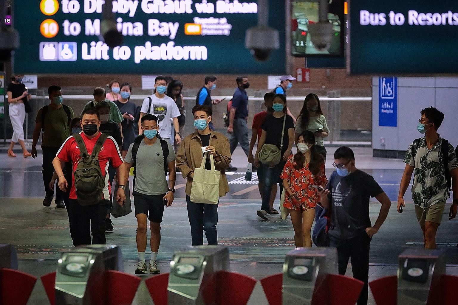 Masked commuters at HarbourFront station yesterday. Temasek Foundation is working with CapitaLand malls and supermarkets to distribute the masks, which households can collect by presenting their utility bills. Each household will get 50 medical-grade