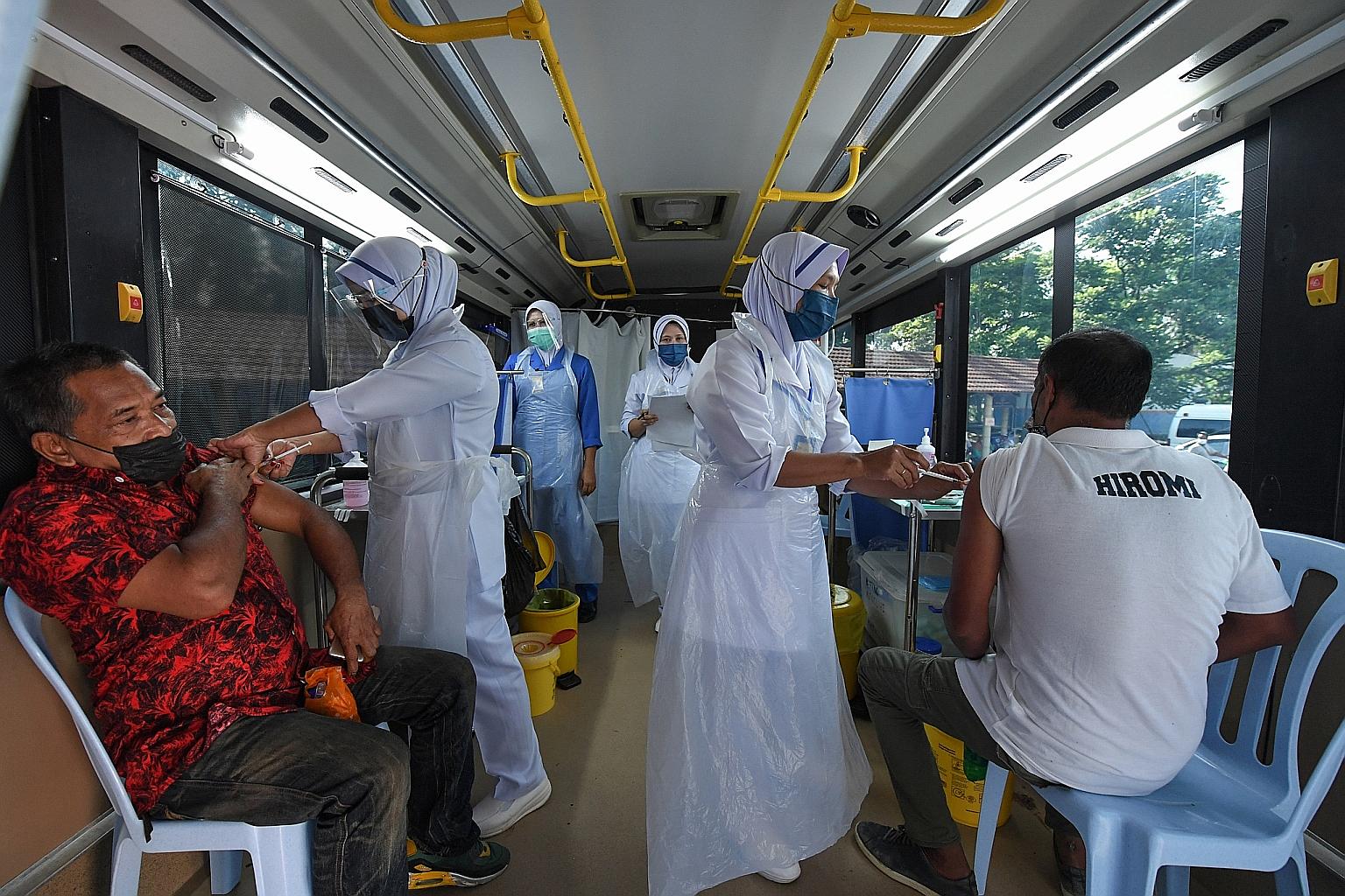 Health workers administering Covid-19 vaccine shots to residents of Felda Bukit Bading in Terengganu on Tuesday. With new Covid-19 infections piling up, the Malaysian government is focusing on speeding up its vaccination drive. PHOTO: BERNAMA