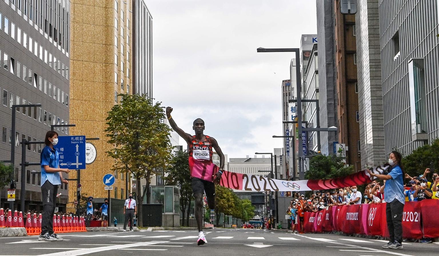 Kenya's Eliud Kipchoge pumping his fist after crossing the Olympic marathon finish line in Sapporo yesterday. Marathon-mad Japanese fans, who defied the Olympic organisers' request to stay away due to Covid-19, lined the streets of the city and cheer