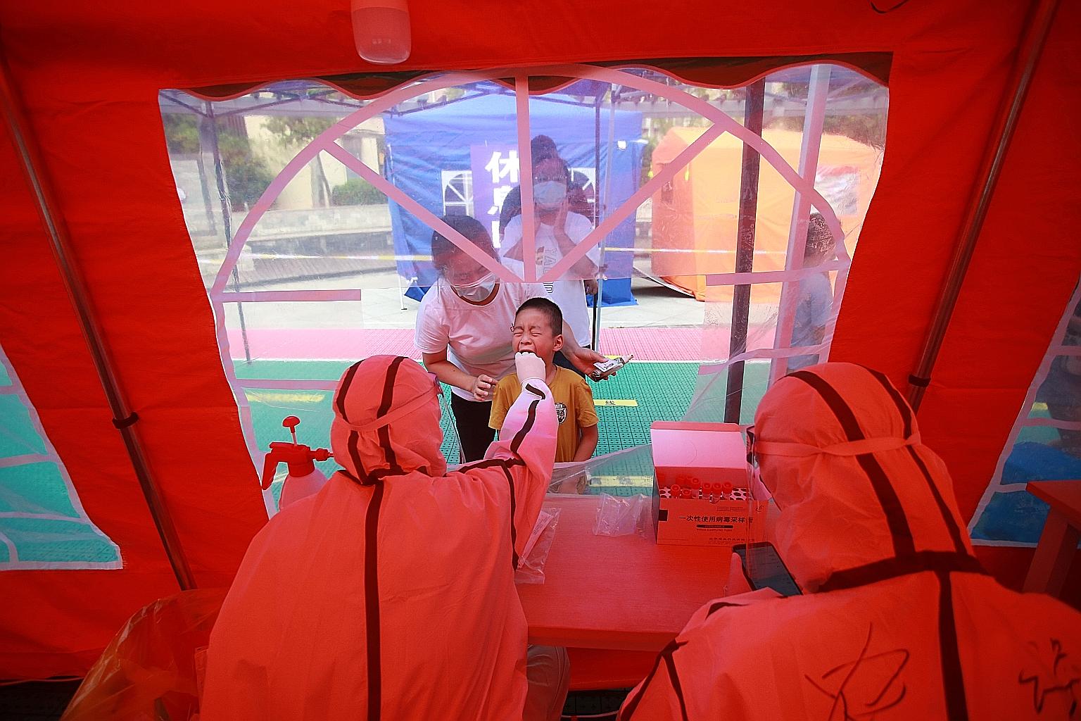 A boy getting a swab on Monday following the Covid-19 outbreak in Yangzhou, Jiangsu province. The city has conducted five rounds of testing so far, collecting 1.6 million samples in an attempt to stamp out the spread.