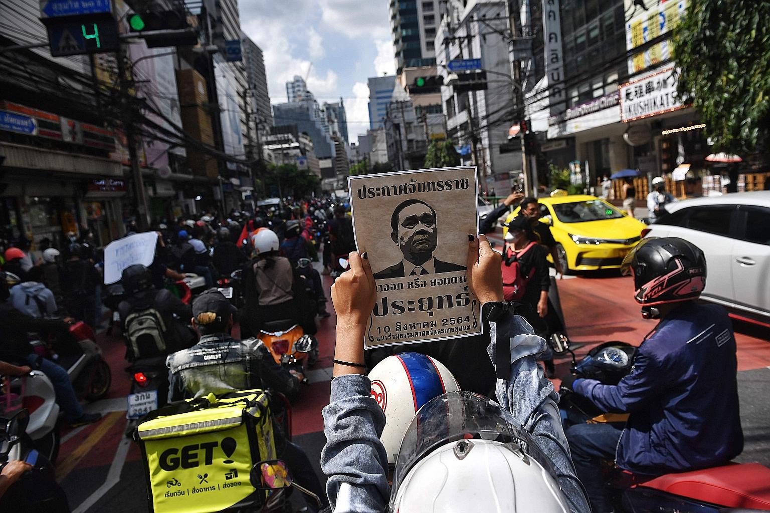 Pro-democracy protesters in Bangkok yesterday holding signs during a "car convoy" protest calling for the resignation of Prime Minister Prayut Chan-o-cha over his government's handling of the Covid-19 crisis, accusing it of mismanaging the pandemic a