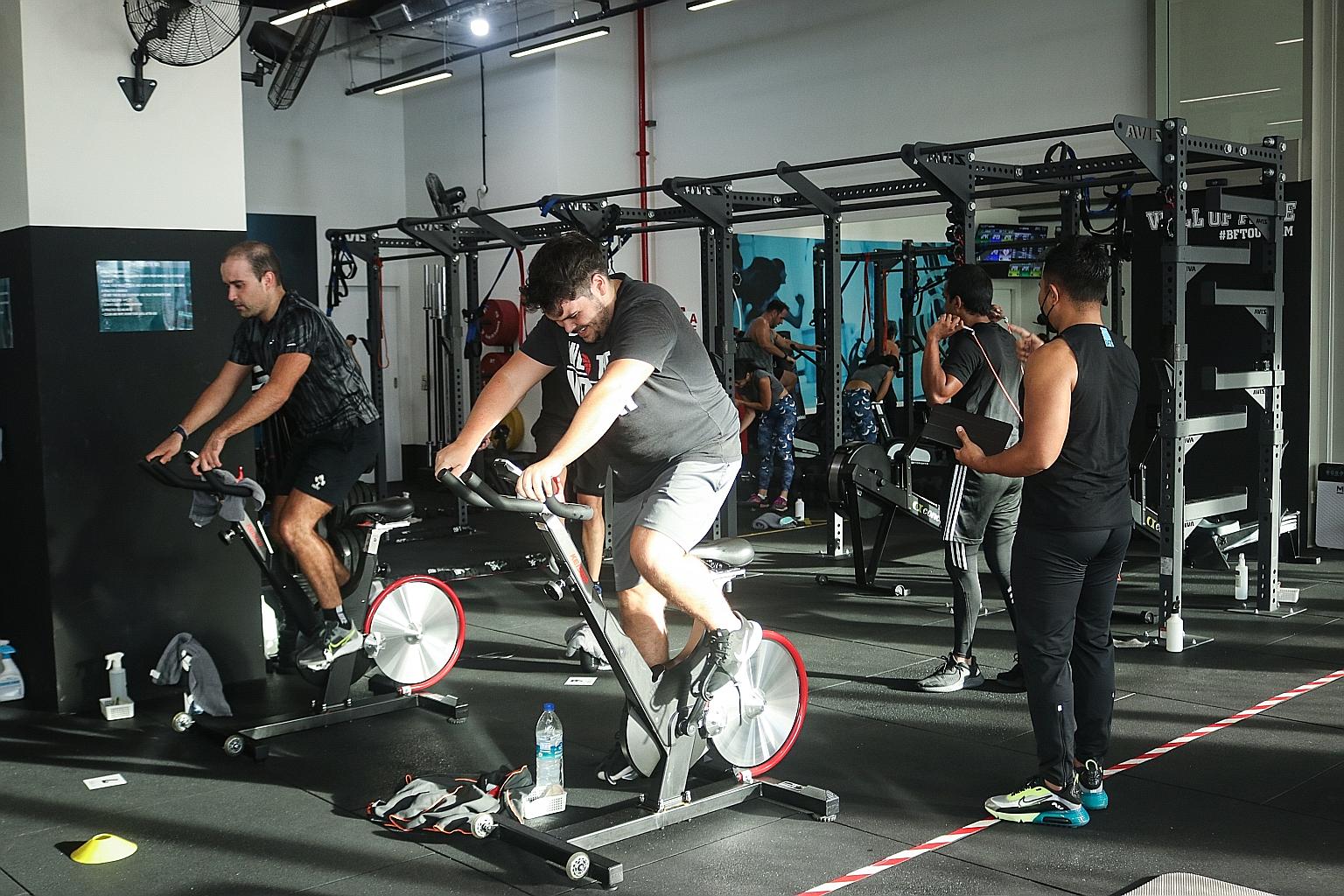Participants at a gym session yesterday at Body Fit Training Outram. Staff of the gyms that The Straits Times visited were seen checking with members for proof of full vaccination or negative pre-event tests before they were allowed to engage in mask