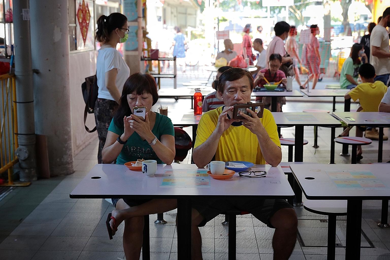 Diners at Jurong West 505 Market and Food Centre yesterday, when dining in at eateries was allowed to resume after a ban that had been in place since July 22. At hawker centres and coffee shops, the group size for dining in is capped at two, regardle