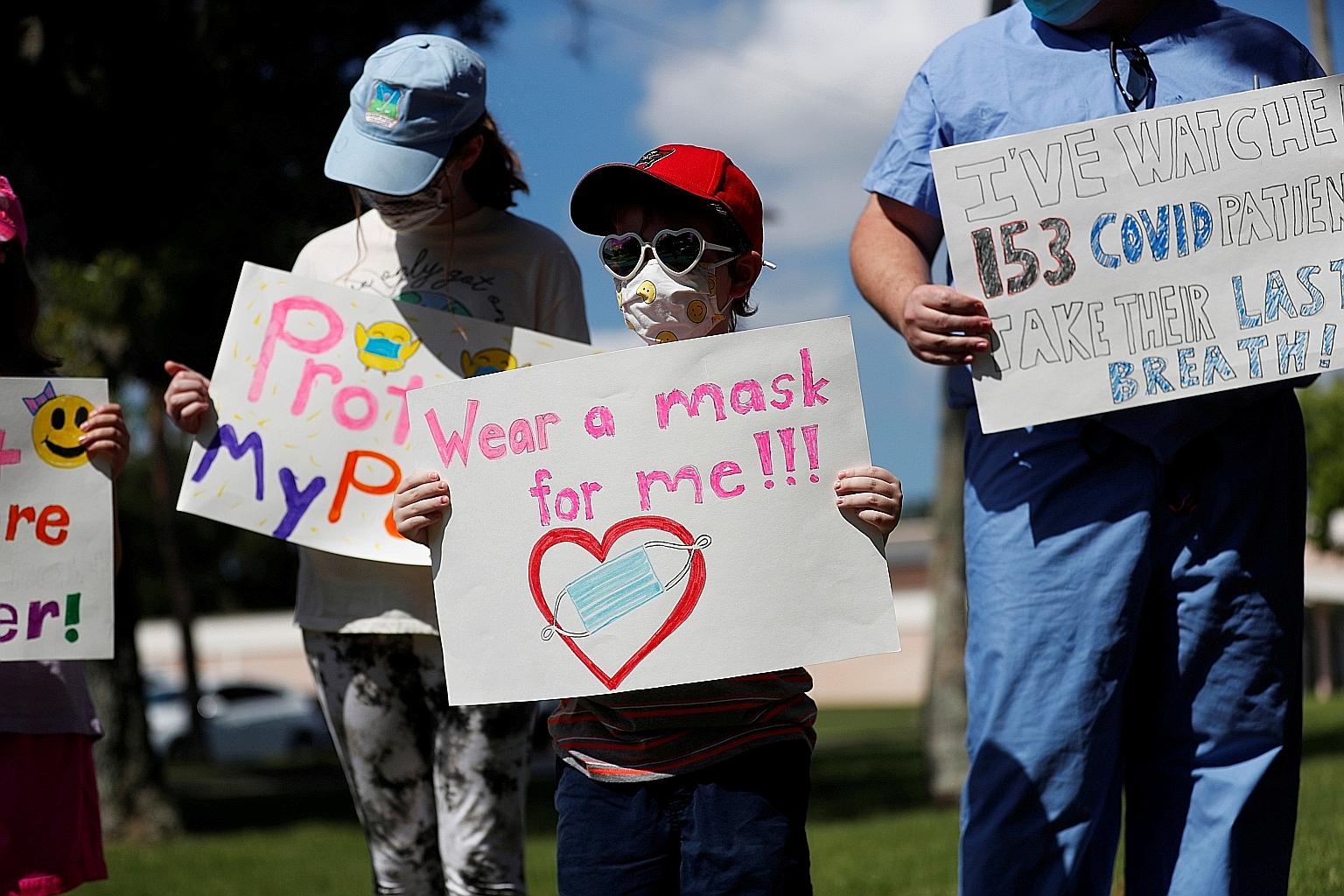 Children calling for masks to be worn at a protest outside the Pinellas County Schools Administration Building in Largo, Florida, on Monday. The state's Republican Governor Ron DeSantis has outlawed mask requirements and threatened to withhold salari