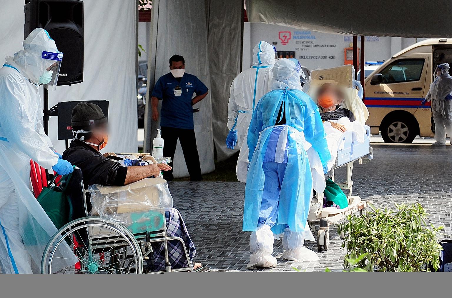 Healthcare workers with Covid-19 patients at Tengku Ampuan Rahimah Hospital in Klang, Selangor, on Sunday. Public and private hospitals in Malaysia are bursting at the seams as daily Covid-19 cases surge. PHOTO: BERNAMA
